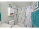 Bright bathroom featuring a shower with marble-look walls, toilet, and cabinet storage at 3175 Lakatos St, North Port, FL 34286