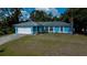 Charming single-story home featuring a blue exterior, well-maintained lawn, and attached two-car garage at 3175 Lakatos St, North Port, FL 34286