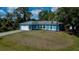 Inviting one-story residence showcasing a blue exterior, lush front yard, and convenient attached garage at 3175 Lakatos St, North Port, FL 34286