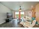 Relaxing living area showcasing tile floors, comfortable seating, and natural light from large windows at 3175 Lakatos St, North Port, FL 34286