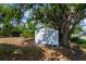 An outdoor storage shed is nestled among mature trees in the backyard at 3175 Lakatos St, North Port, FL 34286