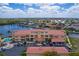 Aerial view showcasing building's architecture, convenient parking, green spaces, and nearby waterways at 3334 Purple Martin Dr # 214, Punta Gorda, FL 33950