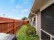 Backyard featuring wood fence, lush green grass, a small shed, and well-maintained landscaping at 3561 Middletown St, Port Charlotte, FL 33952