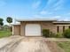 Attached one car garage features a white door and neat landscaping at 3561 Middletown St, Port Charlotte, FL 33952