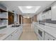 Well-lit kitchen with a skylight, stainless steel sink, and a convenient pass-through to the adjacent living space at 3561 Middletown St, Port Charlotte, FL 33952