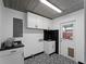 Modern laundry room featuring black and white patterned floor, shaker cabinets, and accenting hardware at 3561 Middletown St, Port Charlotte, FL 33952