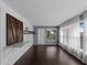 Bright living room featuring wood floors, white shiplap walls, large windows with sheer curtains, and decorative barn door at 3561 Middletown St, Port Charlotte, FL 33952