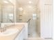 Bathroom featuring a sink, vanity mirror, and tiled walk-in shower with glass door at 4260 Kessler Ter, North Port, FL 34287