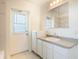 Clean bathroom with a mirrored vanity and door to the outside at 4260 Kessler Ter, North Port, FL 34287