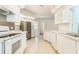 Well-lit kitchen with white cabinetry, tiled floors, modern appliances, and ample counter space at 4260 Kessler Ter, North Port, FL 34287