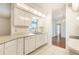 Modern kitchen with white cabinetry, tiled floors, and stainless steel appliances at 4260 Kessler Ter, North Port, FL 34287