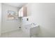 Functional laundry room features a utility sink and storage cabinet at 4260 Kessler Ter, North Port, FL 34287