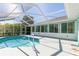 Backyard pool in screened enclosure surrounded by lush landscaping, leads to sunroom at 4260 Kessler Ter, North Port, FL 34287