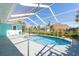 Backyard pool in screened enclosure surrounded by lush landscaping at 4260 Kessler Ter, North Port, FL 34287