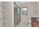 Bathroom featuring tiled floors, a walk-in shower with glass doors, and a wire storage shelf at 428 Briarwood Rd, Venice, FL 34293