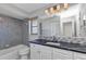 Updated bathroom features a sleek black countertop and modern gray tile shower-tub combination at 428 Briarwood Rd, Venice, FL 34293