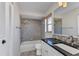 Bright bathroom featuring white cabinetry, black countertops, and a tiled shower-tub at 428 Briarwood Rd, Venice, FL 34293