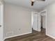 Neutral bedroom with wood-look floors, a ceiling fan, and white trim accents at 428 Briarwood Rd, Venice, FL 34293
