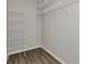 Walk-in closet featuring white shelving for organization and laminate flooring at 428 Briarwood Rd, Venice, FL 34293