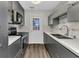 Modern kitchen with gray cabinets, quartz countertops, stainless steel appliances, and access to the backyard at 428 Briarwood Rd, Venice, FL 34293