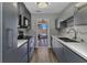 Galley kitchen with stainless steel appliances, gray cabinets, and access to a screened patio at 428 Briarwood Rd, Venice, FL 34293