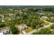 This aerial view shows this home with a two-car garage and is nestled within a lush and verdant wooded neighborhood at 4461 La France Ave, North Port, FL 34286
