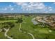 Aerial view showcasing the golf course and community amenities, with a mix of natural ponds and mature trees at 4461 La France Ave, North Port, FL 34286