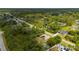 An aerial view shows this single-story home with solar panels, a side shed, and a big lot surrounded by verdant greenery at 4461 La France Ave, North Port, FL 34286