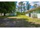 Spacious backyard featuring a detached garage, mature trees, and ample room for outdoor activities at 4461 La France Ave, North Port, FL 34286