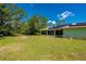 Lush backyard with expansive lawn, a bird bath, and a home featuring solar panels at 4461 La France Ave, North Port, FL 34286