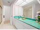 Bathroom with green countertop, large mirrors and a shower at 4461 La France Ave, North Port, FL 34286