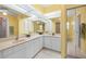 Bathroom featuring double sinks, large mirrors and tile flooring at 4461 La France Ave, North Port, FL 34286
