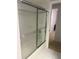 Bright bathroom featuring a shower with frosted glass sliding doors and white tile flooring at 4461 La France Ave, North Port, FL 34286