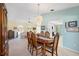 Formal dining area with chandelier lighting and views into the living room and kitchen at 4461 La France Ave, North Port, FL 34286