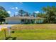 Charming single-story home with a well-manicured lawn, attached garage, and lush landscaping at 4461 La France Ave, North Port, FL 34286
