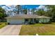 Charming single-story home with a well-manicured lawn, attached two car garage, and lush surrounding greenery at 4461 La France Ave, North Port, FL 34286