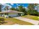 Charming single-story home with a well-manicured lawn, attached two car garage, and lush surrounding greenery at 4461 La France Ave, North Port, FL 34286