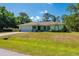 Charming single-story home with a well-manicured lawn, attached garage, and lush landscaping at 4461 La France Ave, North Port, FL 34286