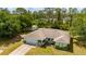 This single-story home has a well-manicured lawn, charming details, and a peaceful, tree-filled backdrop at 4461 La France Ave, North Port, FL 34286