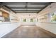 Empty garage with concrete floor, windows, and storage shelves, ready for customization at 4461 La France Ave, North Port, FL 34286