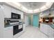 Spacious kitchen featuring white cabinets, white tile floors, and modern appliances at 4461 La France Ave, North Port, FL 34286