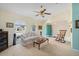 Bright living room featuring arched windows, ceiling fan, and neutral carpet, creating a cozy atmosphere at 4461 La France Ave, North Port, FL 34286