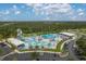 Aerial view of the community pool with slides, lounge chairs, and a splash area, surrounded by lush greenery at 4461 La France Ave, North Port, FL 34286