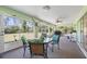 Relaxing sunroom with views of the backyard, table, fan and lush greenery at 4461 La France Ave, North Port, FL 34286