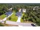An aerial view showcases the property's location within a lush, wooded neighborhood at 4880 Cornsilk Ter, North Port, FL 34286
