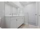 Bright bathroom featuring double sinks, white cabinetry and a glass enclosed shower at 4880 Cornsilk Ter, North Port, FL 34286