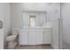 Bright bathroom featuring double sinks, white cabinetry and a glass enclosed shower at 4880 Cornsilk Ter, North Port, FL 34286
