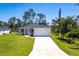 Charming single-story home with a well-manicured lawn, a two car garage, and a long driveway at 4880 Cornsilk Ter, North Port, FL 34286