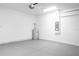 A well-lit garage featuring a gray epoxy floor, a water heater, and a garage door opener at 4880 Cornsilk Ter, North Port, FL 34286