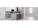Well-equipped kitchen with stainless steel appliances, an island, and neutral gray-and-white finishes at 4880 Cornsilk Ter, North Port, FL 34286